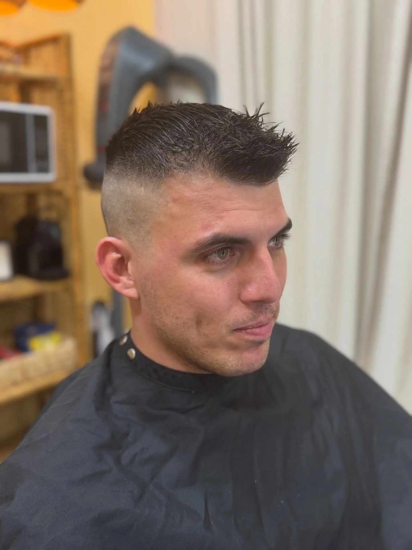 Fresh short haircut with closely faded sides and a textured top.