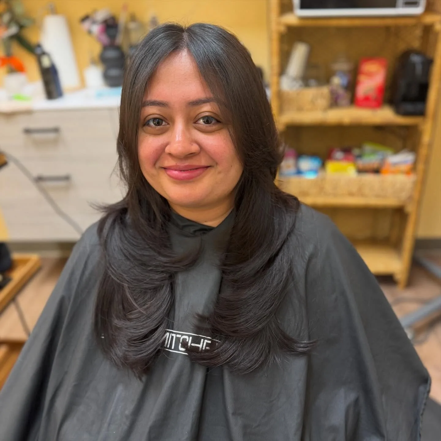 Long dark hair cut into glossy, face-framing layers.